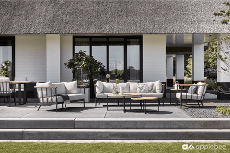 Stijlvolle Apple Bee loungeset met comfortabele kussens en een aluminium frame, prachtig gepresenteerd op een zonnig terras. 