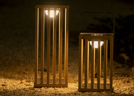 Tuinverlichting sfeerlampen in een tuin met moderne lantaarns die een warme gloed uitstralen.