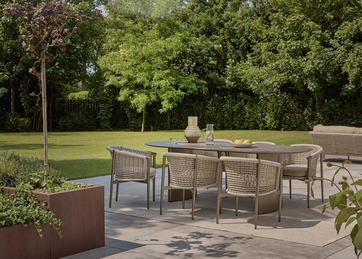 Apple Bee Pulau dining tuinstoelen Champagne rond de tuintafel in een groene tuin