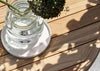 Sfeerfoto van de Apple Bee Condor lounge koffietafel, stijlvol gepresenteerd op een terras, het perfecte middelpunt voor elke buitenruimte